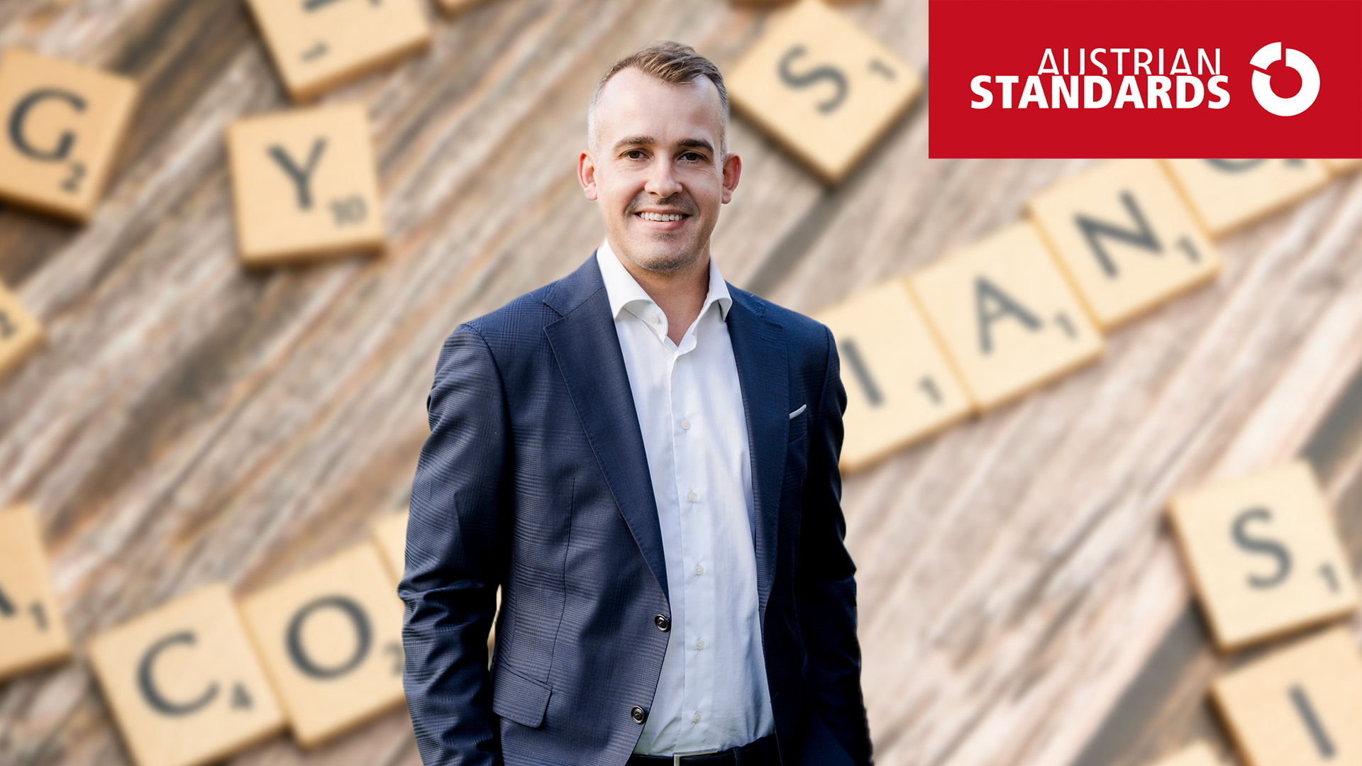 Rechtsanwalt Berthold Hofbauer vor dem Hintergrund von Scrabble Buchstaben, die das Wort Compliance legen